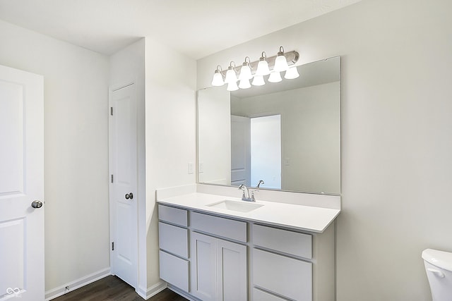 bathroom with hardwood / wood-style floors, toilet, and vanity