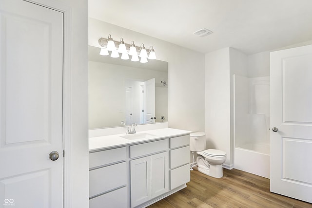 full bathroom featuring hardwood / wood-style floors, toilet, vanity, and shower / washtub combination