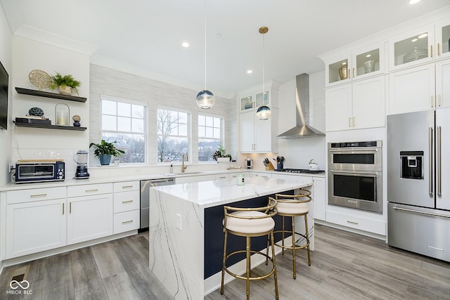 kitchen with white cabinets, stainless steel appliances, and wall chimney exhaust hood