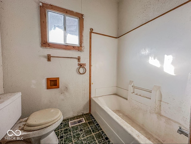 bathroom with a bathing tub and toilet