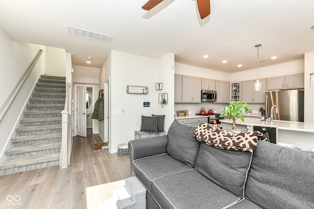 living room with ceiling fan and light hardwood / wood-style floors