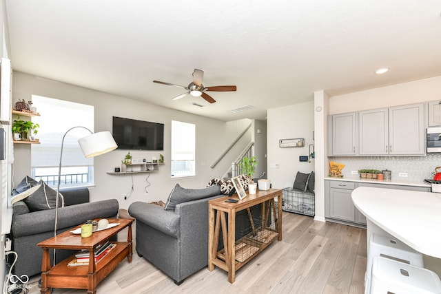 living room featuring ceiling fan and light hardwood / wood-style floors