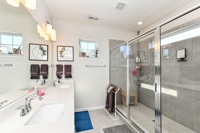 bathroom with walk in shower, vanity, and tile patterned flooring