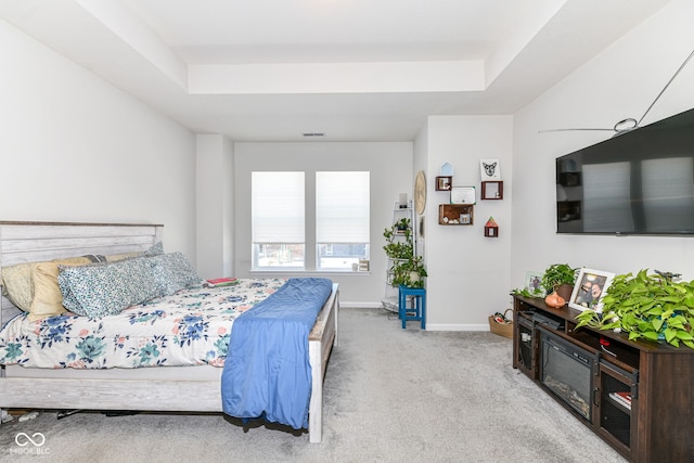 carpeted bedroom with a tray ceiling