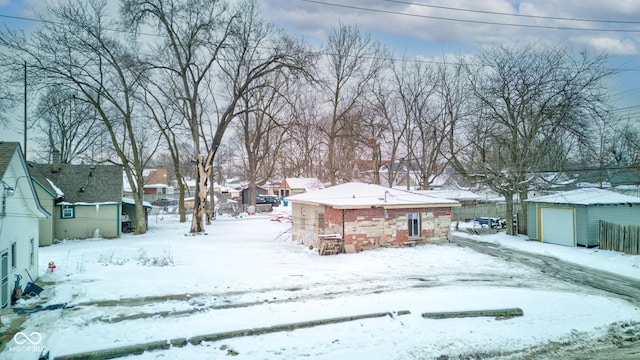 yard covered in snow featuring an outbuilding