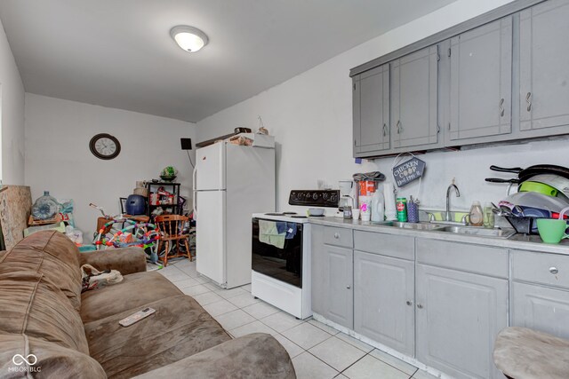 kitchen featuring gray cabinetry, white appliances, sink, and light tile patterned floors