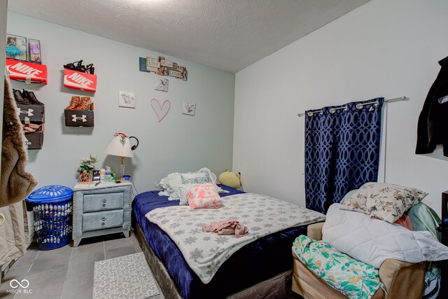 tiled bedroom featuring a textured ceiling