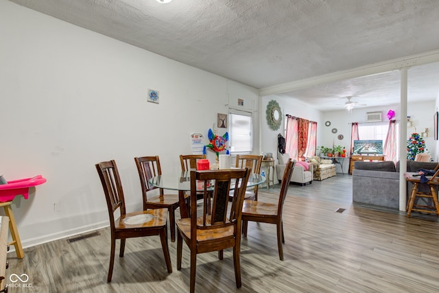 dining room featuring ceiling fan, a textured ceiling, and light wood-type flooring