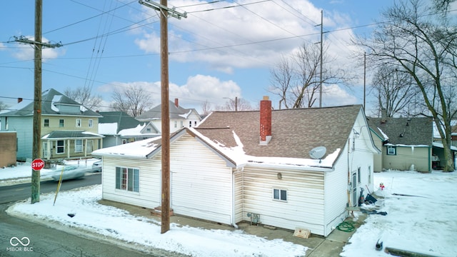 view of snow covered back of property