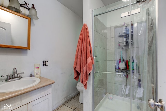 bathroom featuring a shower with door, vanity, tile patterned flooring, and toilet