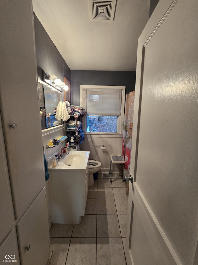 bathroom with tile patterned flooring, vanity, and toilet