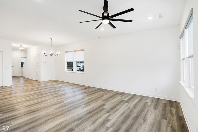 unfurnished living room featuring light hardwood / wood-style floors and ceiling fan with notable chandelier