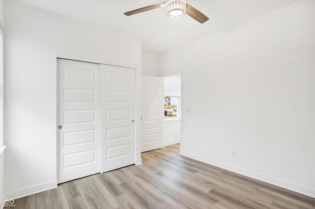 unfurnished bedroom featuring ceiling fan, light hardwood / wood-style floors, and a closet