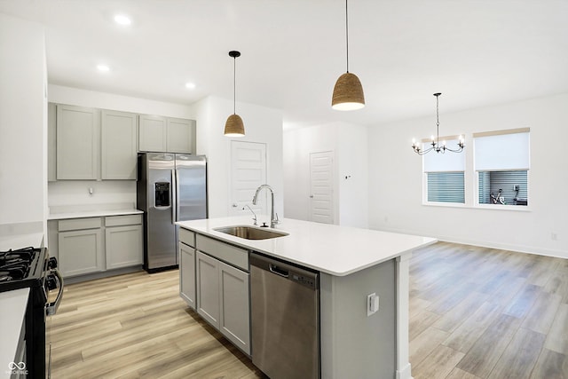 kitchen featuring appliances with stainless steel finishes, gray cabinets, pendant lighting, and sink