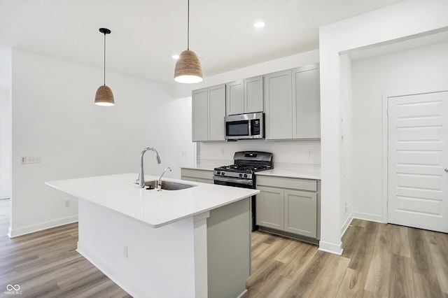 kitchen with sink, stainless steel appliances, gray cabinets, and pendant lighting