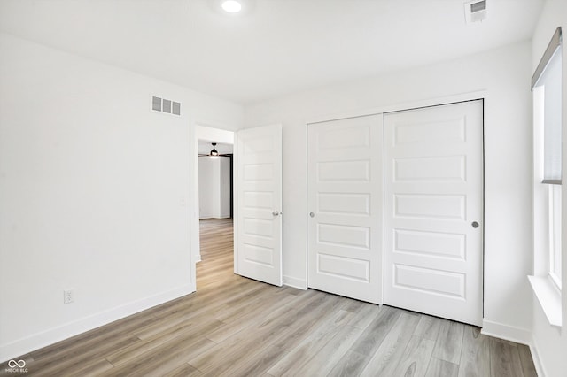 unfurnished bedroom featuring a closet and light hardwood / wood-style flooring