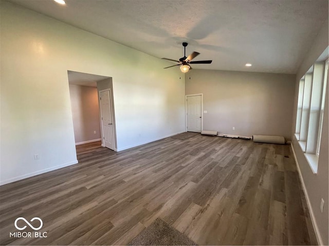 spare room with a textured ceiling, ceiling fan, dark hardwood / wood-style flooring, and lofted ceiling