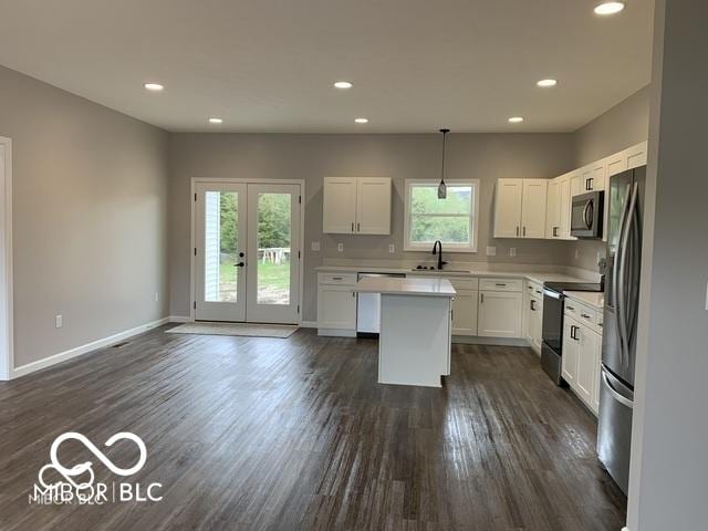 kitchen with french doors, stainless steel appliances, sink, decorative light fixtures, and white cabinetry