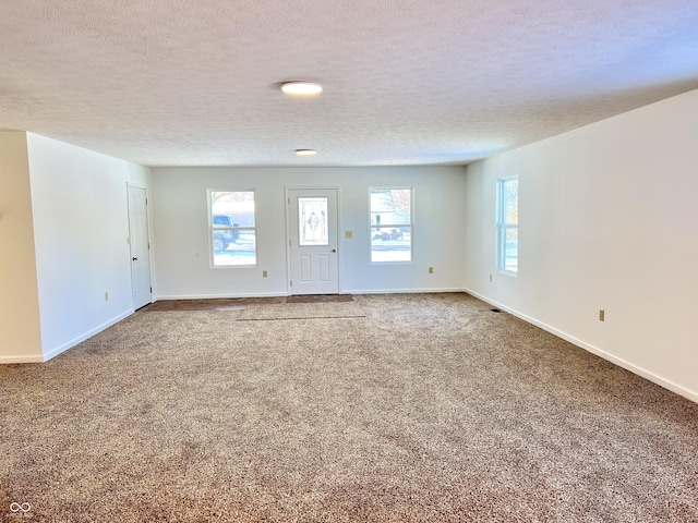 carpeted empty room featuring a textured ceiling