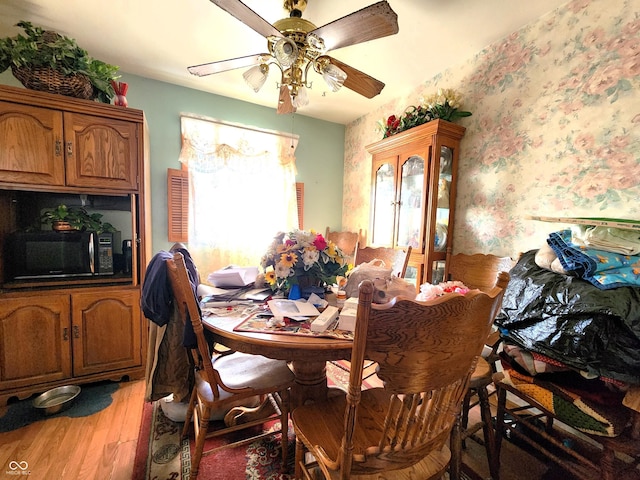 dining space with hardwood / wood-style floors and ceiling fan