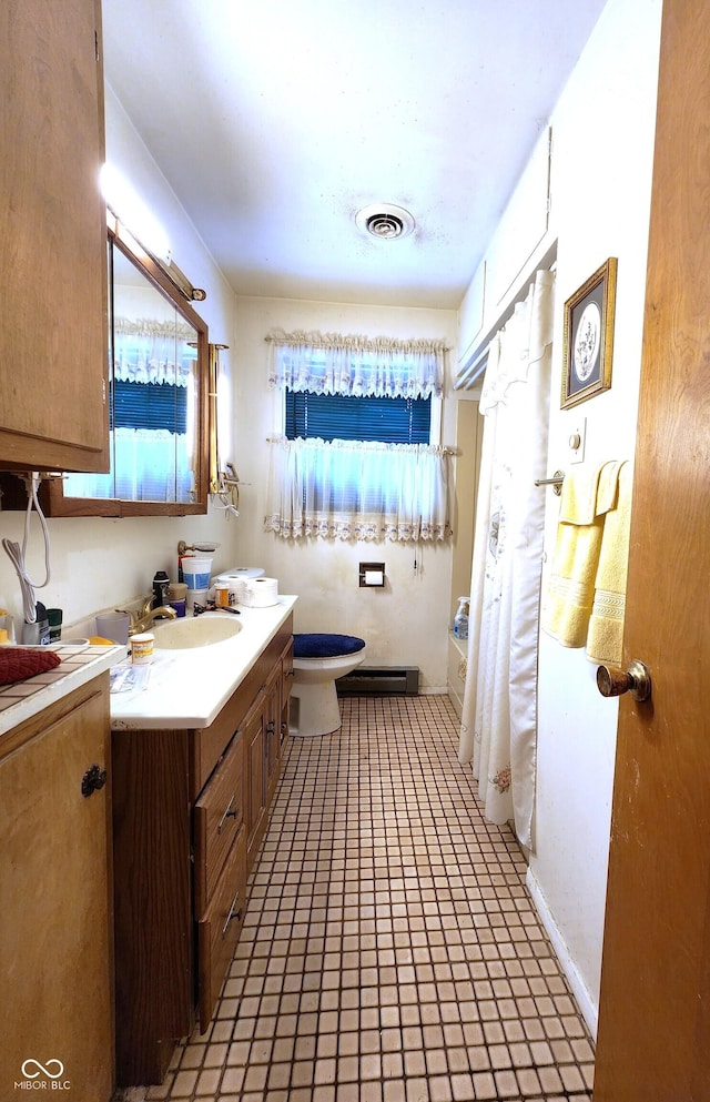 bathroom featuring vanity, toilet, and a baseboard radiator