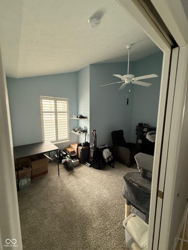 interior space with carpet flooring, a textured ceiling, ceiling fan, and lofted ceiling