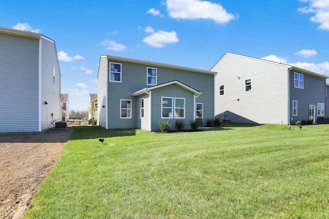 back of house featuring cooling unit and a yard