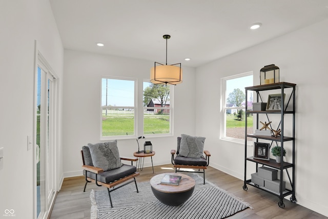 sitting room featuring baseboards, wood finished floors, and recessed lighting