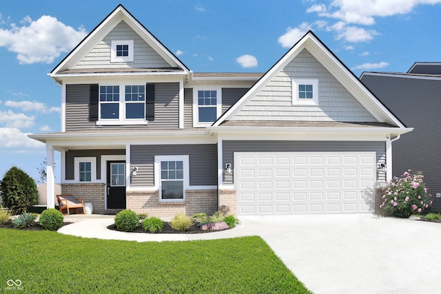 craftsman inspired home featuring a garage, driveway, a front lawn, and brick siding