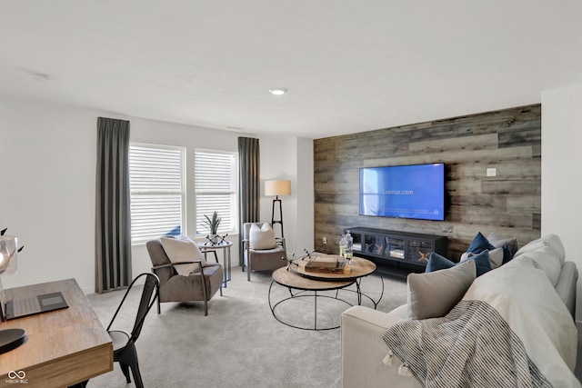 living area featuring an accent wall, light colored carpet, and wood walls