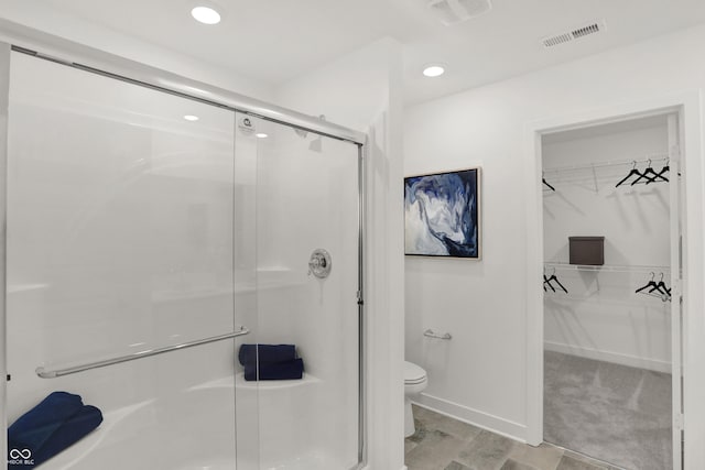 full bath featuring toilet, a spacious closet, a stall shower, and visible vents