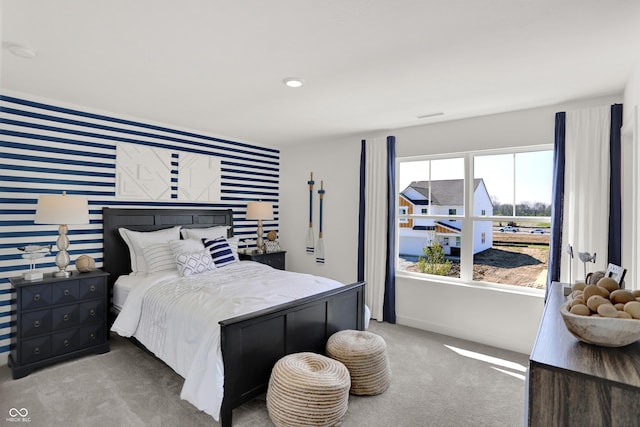 bedroom featuring an accent wall, carpet floors, visible vents, baseboards, and wallpapered walls