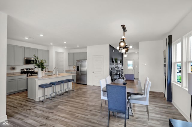 dining room featuring a chandelier, recessed lighting, light wood-style flooring, and baseboards