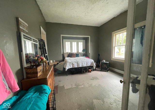 bedroom with a textured ceiling and multiple windows