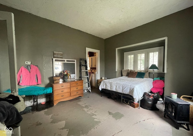 bedroom featuring a textured ceiling and a wood stove