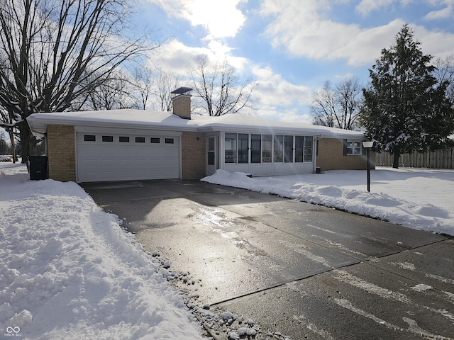 ranch-style home featuring a garage and a sunroom