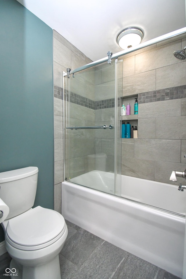 bathroom with toilet and bath / shower combo with glass door