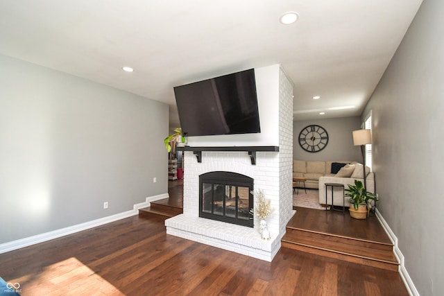 living room featuring a fireplace and dark wood-type flooring