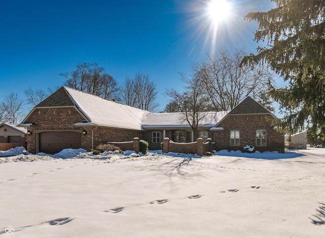 snow covered property with a garage