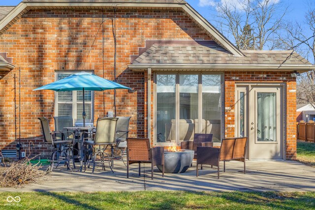 rear view of property featuring a fire pit and a patio area