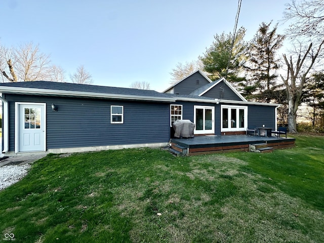 rear view of house with a yard and a wooden deck