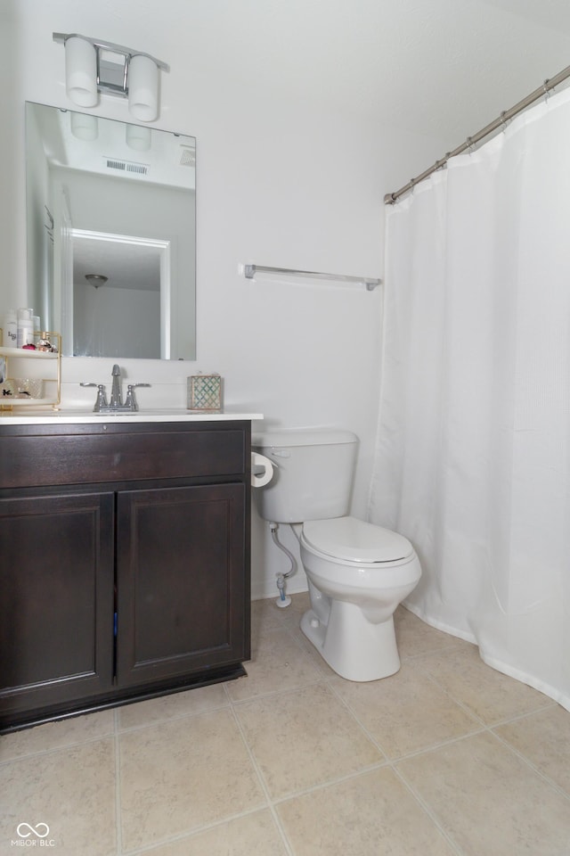 bathroom with tile patterned flooring, vanity, and toilet