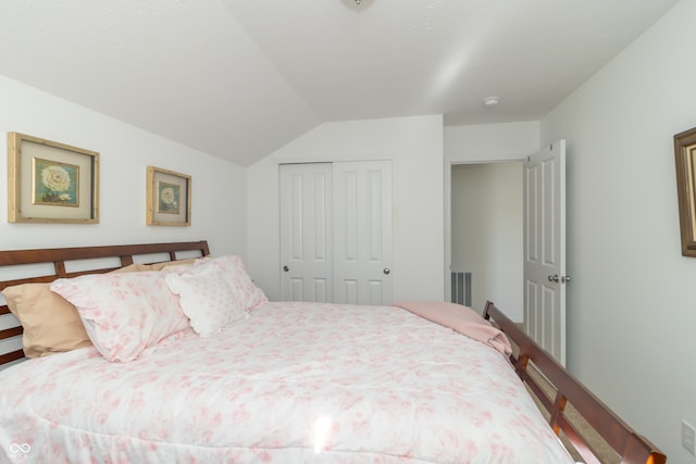 bedroom with vaulted ceiling and a closet