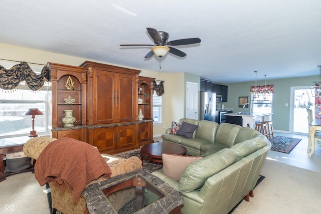 living room featuring a healthy amount of sunlight, ceiling fan, light carpet, and sink