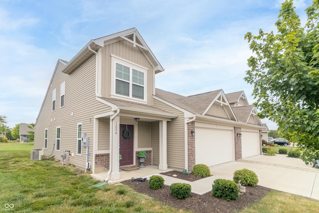 1226 Arlington Dr, Greenfield, IN 46140 - view of front of house with a front lawn, brick siding, concrete driveway, a garage, and board and batten siding