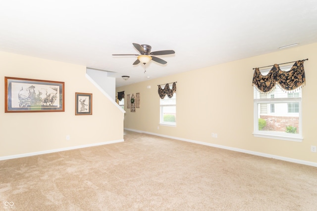 1226 Arlington Dr, Greenfield, IN 46140 - unfurnished living room featuring light colored carpet, a ceiling fan, and stairs
