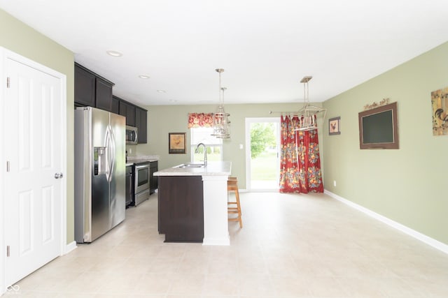 1226 Arlington Dr, Greenfield, IN 46140 - kitchen with stainless steel appliances, a kitchen island with sink, a breakfast bar area, decorative light fixtures, and recessed lighting
