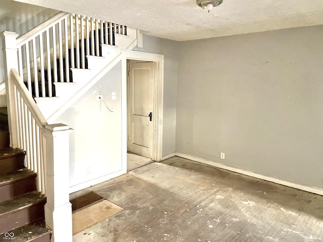 stairs with a textured ceiling