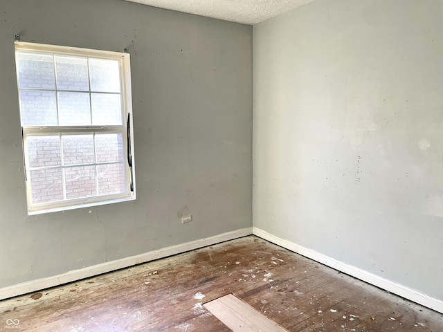 spare room with hardwood / wood-style flooring and a textured ceiling