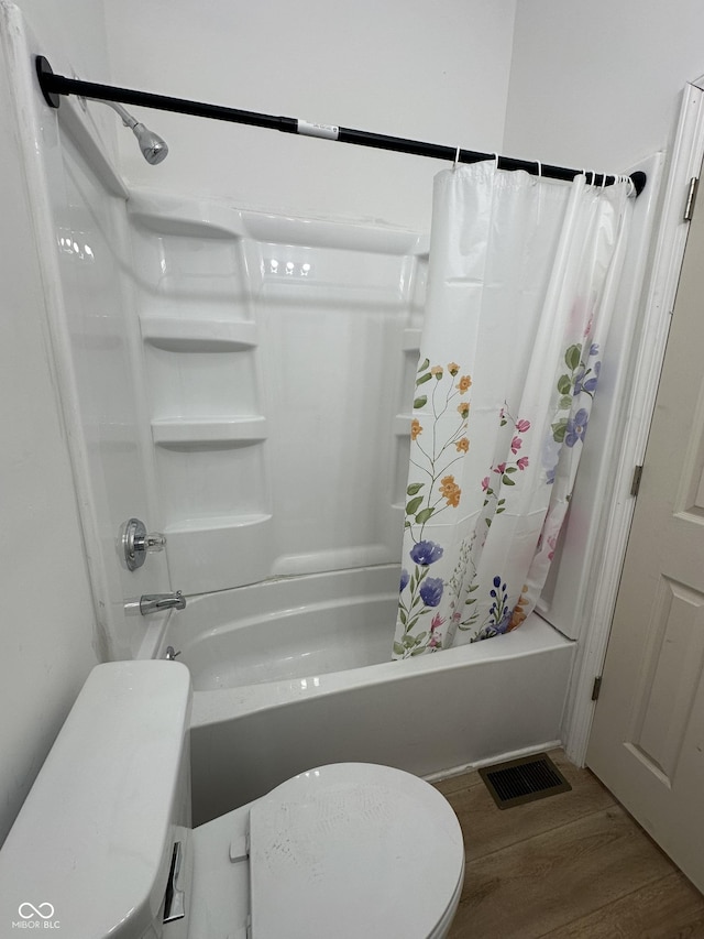 bathroom with wood-type flooring, toilet, and shower / bath combination with curtain